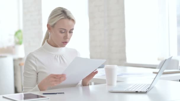 Jeune femme d'affaires lisant des documents dans le bureau moderne — Video