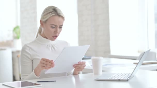 Verontrustend Jonge zakenvrouw leest documenten in kantoor — Stockvideo