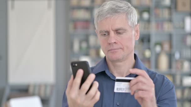 Retrato del exitoso hombre de mediana edad usando tarjeta de crédito en Smartphone — Vídeos de Stock