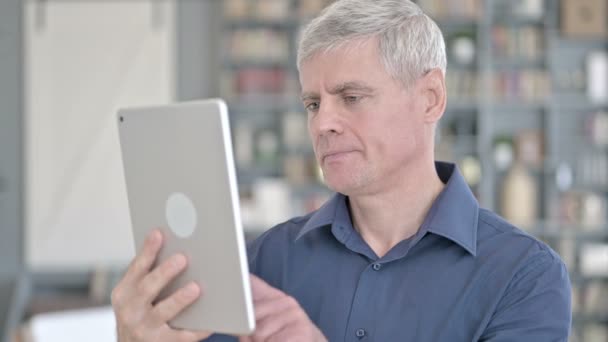 Portrét pohledný muž středního věku dělá video chat na tabletu — Stock video
