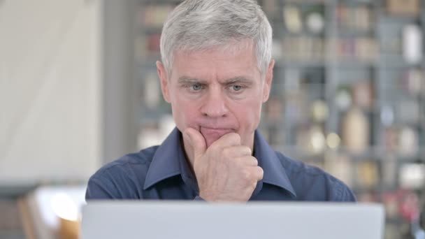 Retrato del hombre de mediana edad Pensando y trabajando en el ordenador portátil — Vídeos de Stock