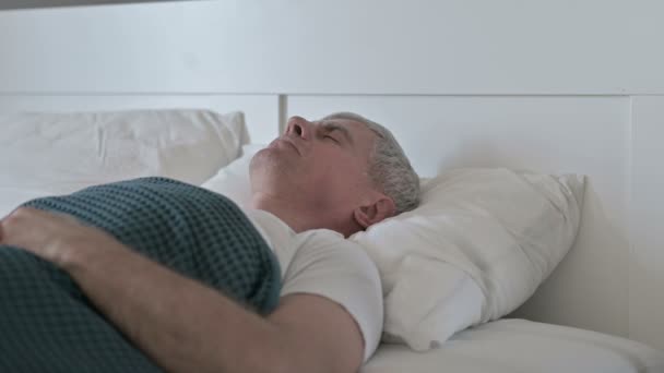 앓고 있는 중년 남자가 침대에서 자는 동안 기침을 하는 모습 — 비디오