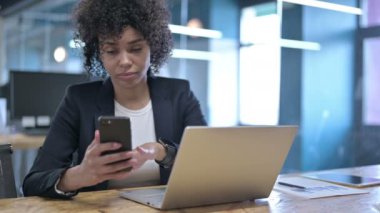 İş yerinde akıllı telefon kullanan ciddi bir iş kadını.