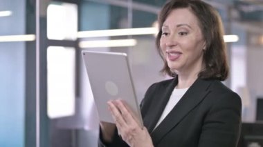 Portrait of Attractive Middle Aged Businesswoman doing Video Chat on Tablet