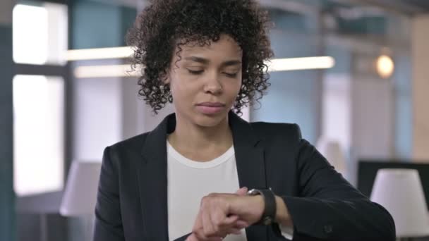 Portret skoncentrowanej afrykańskiej bizneswoman korzystającej z inteligentnego zegarka — Wideo stockowe
