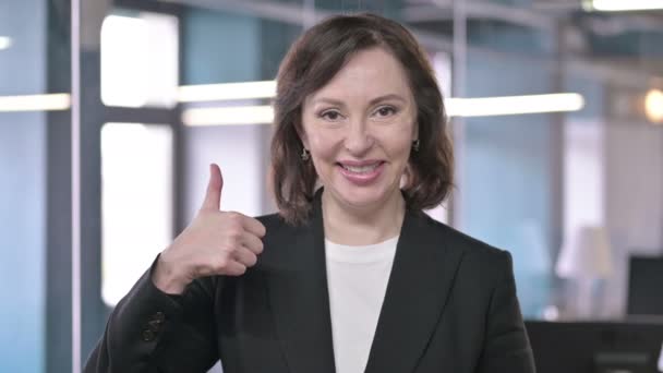 Retrato de la alegre mujer de negocios de mediana edad mostrando pulgares hacia arriba — Vídeos de Stock