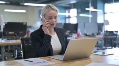 Neşeli İş Kadını İş yerinde Akıllı Telefonla Konuşuyor
