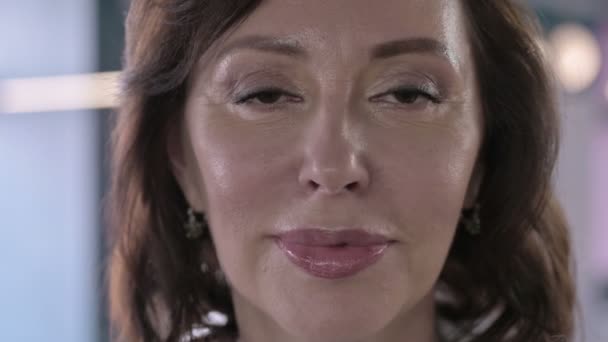 Close-up van mooie middelbare leeftijd witte vrouw kijken naar de camera en glimlachen — Stockvideo