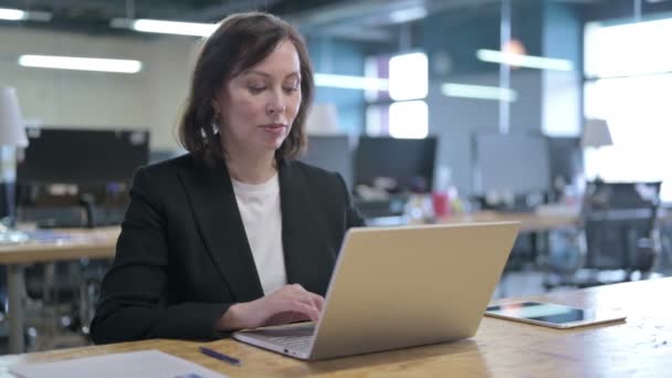 Ciddi Orta Çağ İş Kadını Ofiste Dizüstü bilgisayarda çalışıyor — Stok video