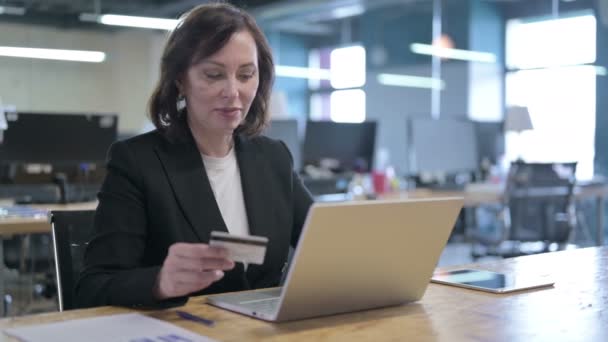 Ernsthafte Geschäftsfrau mittleren Alters macht Online-Zahlung per Kreditkarte auf Laptop — Stockvideo