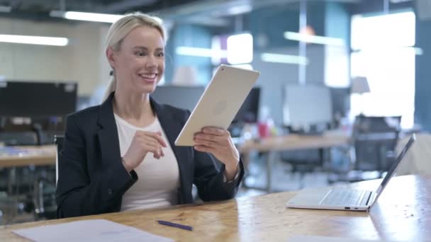 Atrakcyjne Businesswoman robi wideo czat na tablecie w biurze — Wideo stockowe