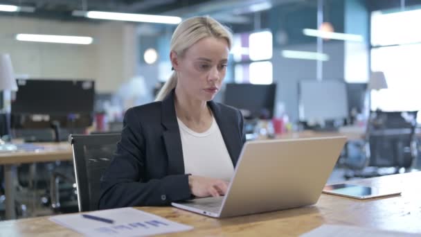 Empresária séria trabalhando no laptop no escritório — Vídeo de Stock