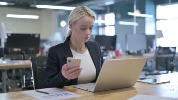 Wesoły Bizneswoman za pomocą smartfona w biurze — Wideo stockowe