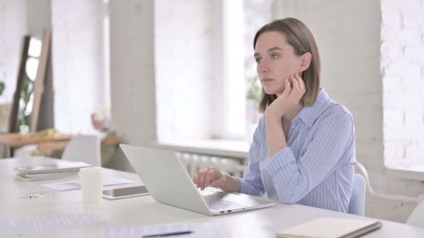 Junge professionelle Frau denkt und arbeitet am Laptop — Stockvideo