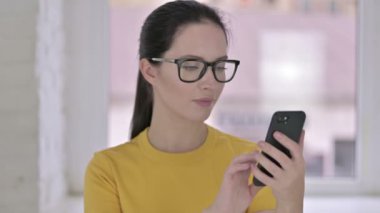 Akıllı Telefon ve Kutlama kullanan Genç Kadın Tasarımcı Portresi