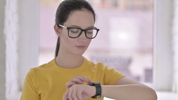 Portret profesjonalnej młodej projektantki korzystającej z inteligentnego zegarka — Wideo stockowe