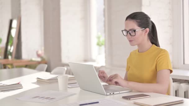 Vrolijke jonge vrouwelijke ontwerper doet videochat op laptop — Stockvideo