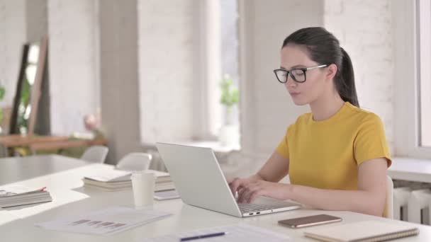 Молодая профессиональная женщина-дизайнер мышление и работа на ноутбуке — стоковое видео