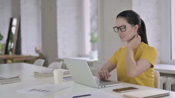 Уставшая молодая дизайнер с болями в шее в современном офисе — стоковое видео