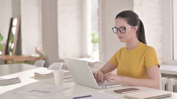 Fókuszált fiatal női tervező Laptopon dolgozik a modern irodában — Stock videók