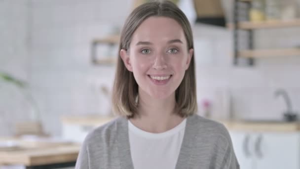 Портрет молодой женщины, улыбающейся и машущей перед камерой — стоковое видео