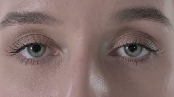 Gros plan de la jeune femme clignotant les yeux à la caméra — Video