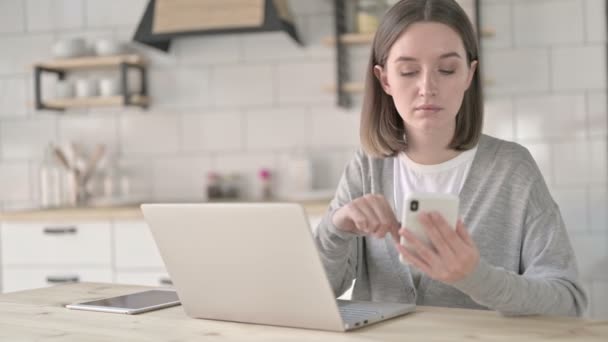 Mladá žena pomocí chytrého telefonu na kancelářském stole — Stock video