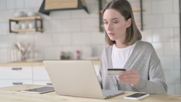 Невдала молода жінка використовує кредитну картку на ноутбуці — стокове відео