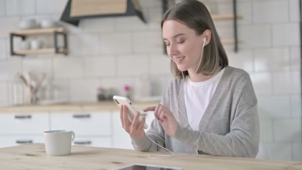 Cheerful Young Woman Listing Music on Smartphone — Stock Video