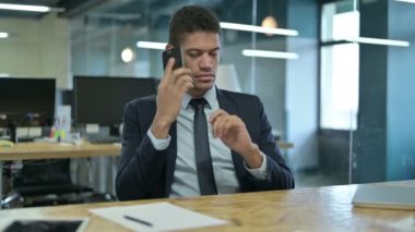 Genç Afrikalı İş Adamı Ofiste Akıllı Telefonla konuşuyor