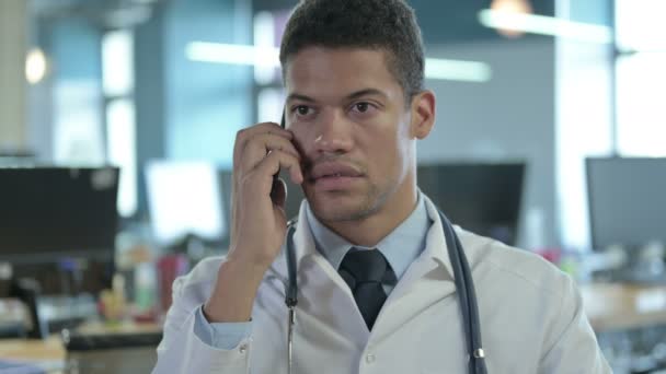 Портрет африканского врача разговаривающего на смартфоне в офисе — стоковое видео