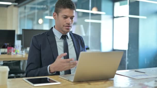 Jeune homme d'affaires africain faisant du chat vidéo sur ordinateur portable — Video