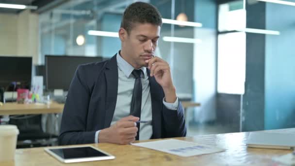 Joven empresario africano Pensando y leyendo documentos — Vídeos de Stock