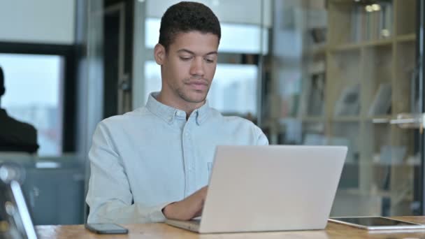 Jonge Afrikaanse man met behulp van laptop in Modern Office — Stockvideo