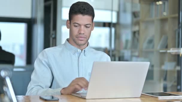 Hombre joven africano usando Smartphone y Laptop — Vídeos de Stock