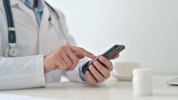 Доктор, який використовує смартфон у клініці, крупним планом — стокове відео