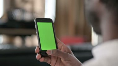Krom Ekran Anahtarlı Akıllı Telefon kullanan Afrikalı Adam 'ın Arka Görünümü 