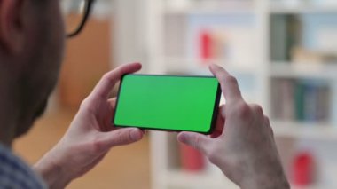 Chroma Key Ekranlı Akıllı Telefon İzleyen Genç Adam 'ın Arka Görünümü 
