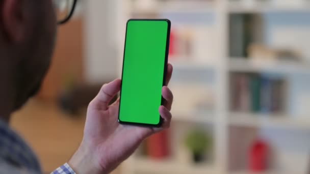 Achteraanzicht van de jongeman met behulp van Smartphone met Chroma Key Screen — Stockvideo