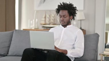 Evde dizüstü bilgisayarı olan Afrikalı Adam Kameraya Gülümsüyor 