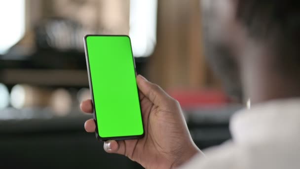 Вид сзади на Африканского человека с помощью смартфона с хромированным экраном — стоковое видео