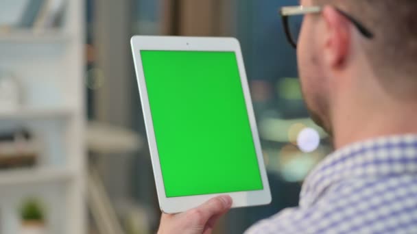 Οπίσθια όψη του νεαρού άνδρα που χρησιμοποιεί tablet με χρωματική βασική οθόνη — Αρχείο Βίντεο