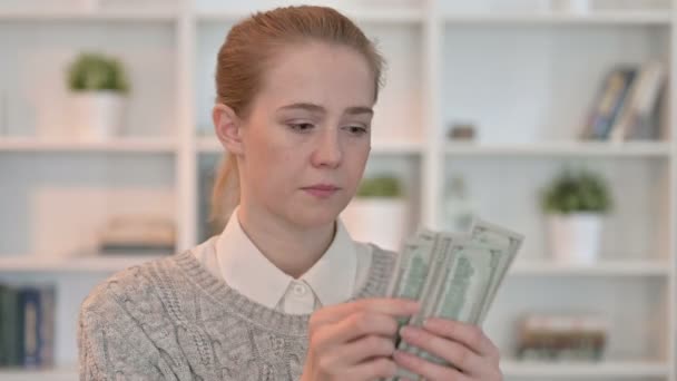 Portret van gefocuste jonge vrouw die dollars telt — Stockvideo