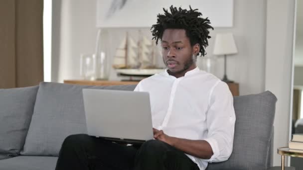 Africký muž slaví úspěch na notebooku doma — Stock video