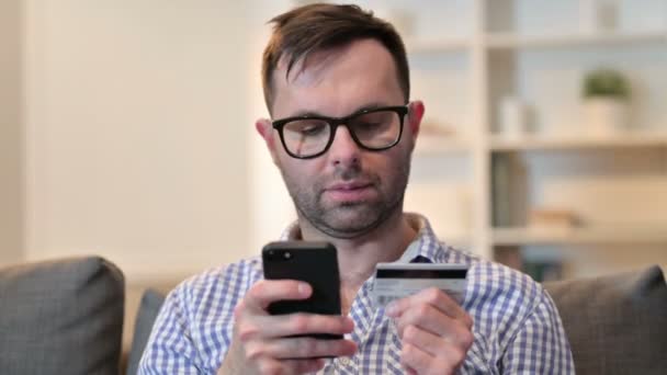 Портрет молодого чоловіка з успіхом онлайн платежів по телефону — стокове відео