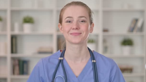 Улыбающаяся молодая женщина-доктор разговаривает по видеосвязи — стоковое видео