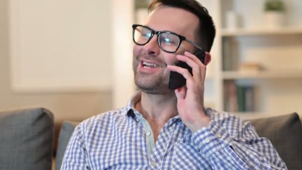 Smartphone 'da konuşan gülümseyen genç adamın portresi — Stok video
