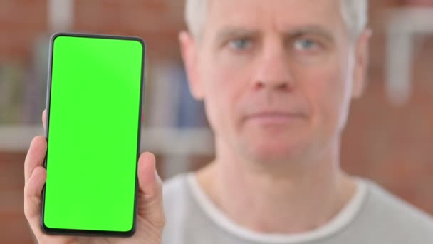 Viejo sonriente sosteniendo Smartphone con pantalla verde — Vídeo de stock