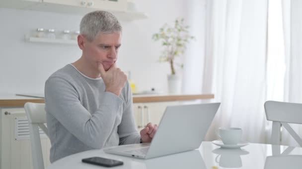 Senior Old Man Thinking en werken op Laptop thuis — Stockvideo