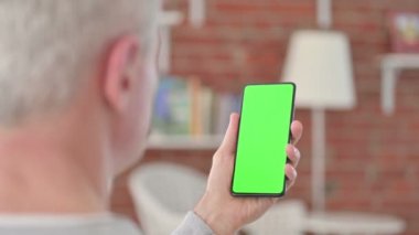 Yaşlı adam Krom Ekranlı Akıllı Telefon kullanıyor. 